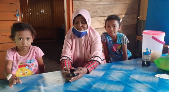 MAMA Nursafa Ibrahim (60), bersama dua cucunya saat dtemui di tempat jualan nasi kuningnya