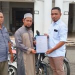 Plt Kabag Kesra Kespul Basiludin La Besi (kanan) saat menyerahkan bantuan tiga unit sepeda motor dan laptop kepada pengurus masjid Al-Istiqomah Sanana, Kamis (24/12/2020)