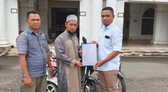 Plt Kabag Kesra Kespul Basiludin La Besi (kanan) saat menyerahkan bantuan tiga unit sepeda motor dan laptop kepada pengurus masjid Al-Istiqomah Sanana, Kamis (24/12/2020)