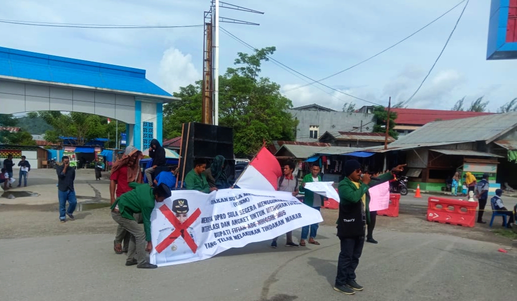 MASSA aksi yang tergabung dalam Gerakan Sula Menggugat (GSM) menggelar aksi di bundaran Desa Fogi, Kecamatan Sanana, Rabu (1/12/2021) dengan membawa spanduk coretan muka Bupati Kepsul FAM