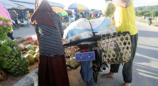 KEGIATAN jual beli kelapa muda di jalan pasar Bobong, Pulau Taliabu pada Senin (18/4/2022)