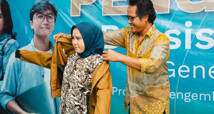 MOMEN penganugerahan Beasiswa Harita Gemilang 2025, saat Community Development Manager Harita Nickel, Broto Suwarso, mengenakan jaket kepada para penerima beasiswa.