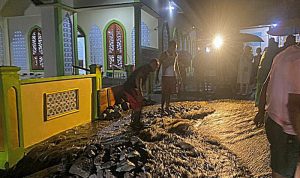 WARGA Kelurahan Tafraka, Pulau Hiri, membersihkan material terbawa banjir akibat luapan embung yang berada di belakang perkampungan.