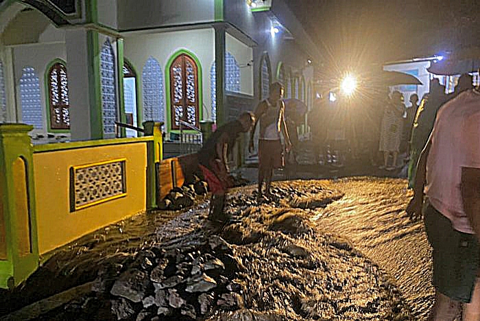 WARGA Kelurahan Tafraka, Pulau Hiri, membersihkan material terbawa banjir akibat luapan embung yang berada di belakang perkampungan.