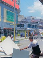 WARGA tampak mengambil sisa-sisa material ACP dinding Plaza Gamalama Modern Ternate untuk menutup akses jalan. (istimewa)